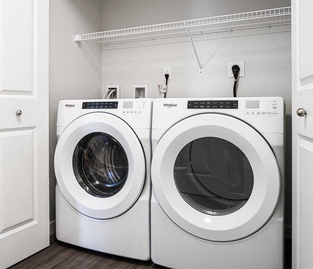 two washing machines in a laundry room with white cabinets