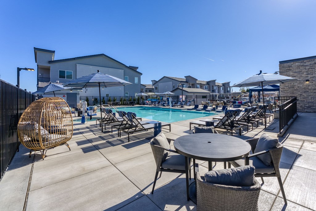 a swimming pool with tables and chairs and umbrellas