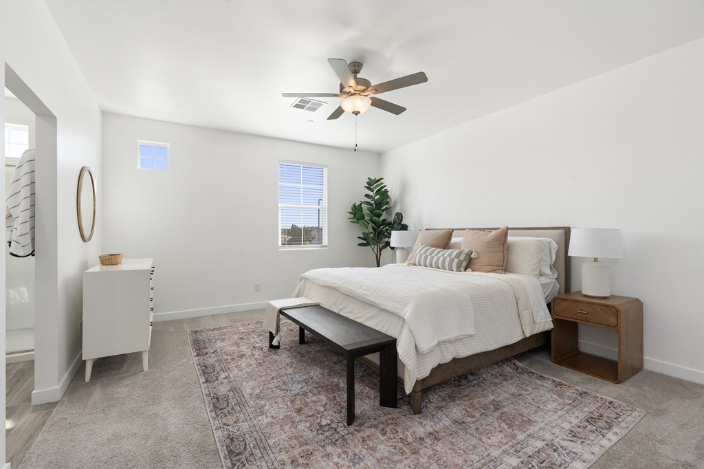 A bedroom with a bed, nightstand, and a rug.