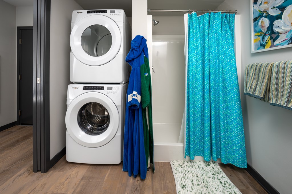 A white washing machine is stacked on top of another one.