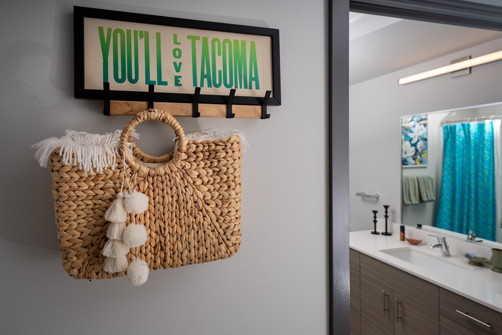 A bathroom with a woven bag hanging on the wall.