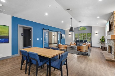 A modern dining room with a wooden table and blue chairs.