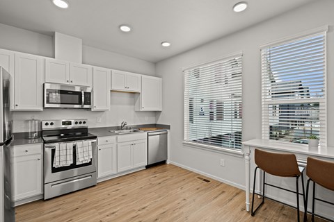 a kitchen with white cabinets and stainless steel appliances and a window