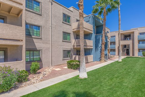 Three story apartment buildings with palm trees at Peak at Oro Valley Apartments, Arizona
