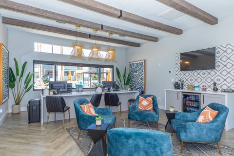 A living room with blue chairs and a television.