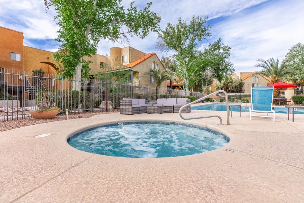 A small pool with a hot tub in the middle of a backyard.
