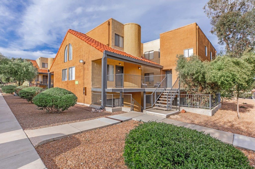 A modern building with a red tile roof and a staircase leading to the entrance.