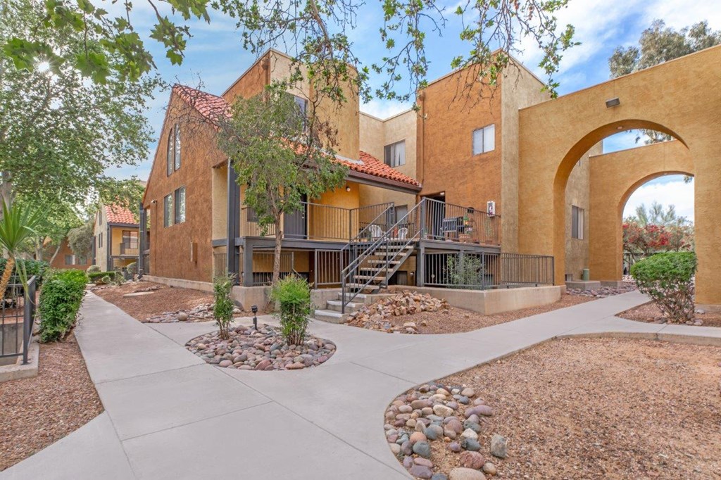 A building with a red roof and a courtyard with a circular stone design.