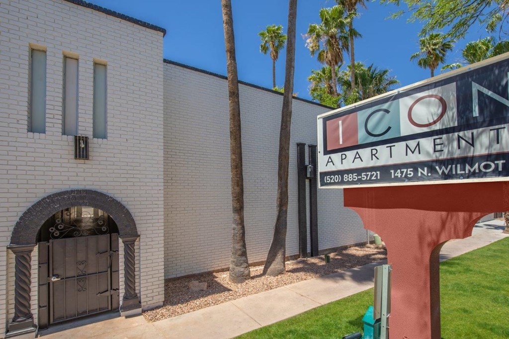 Icon Apartment is a white building with a red sign in front.