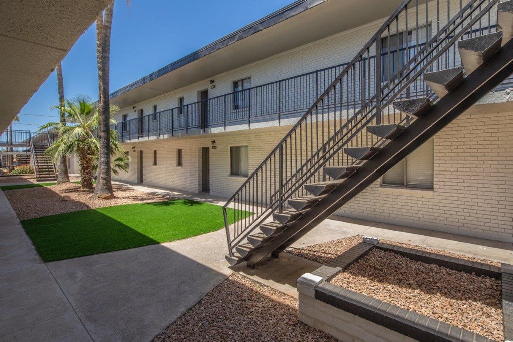A building with a staircase and a palm tree.