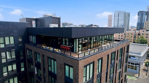 A modern building with a black facade stands out against the city skyline.
