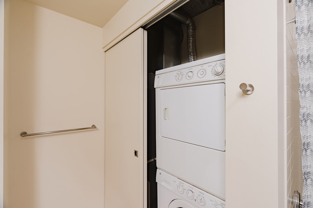A white washing machine is in a small laundry room.