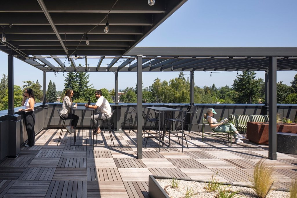 Arts Plaza Gresham Oregon Apartments People are sitting and relaxing on a wooden deck.