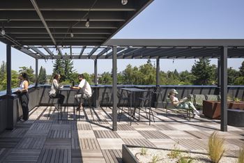 People are sitting and relaxing on a wooden deck.