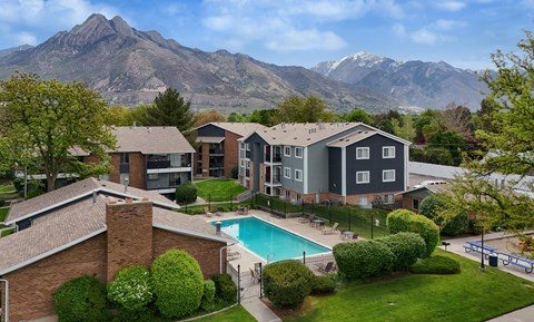 A large house with a pool and mountains in the background.