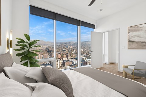 A bedroom with a large bed and a view of the city.