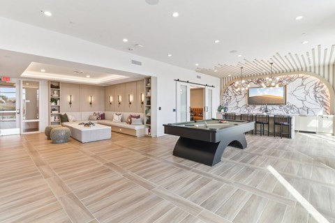 A spacious room with a pool table and a bar area.