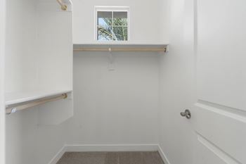 A white bathroom with a window and a door.