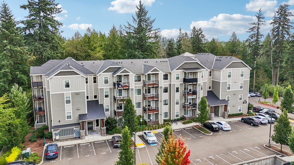 A large apartment complex with a parking lot in front.