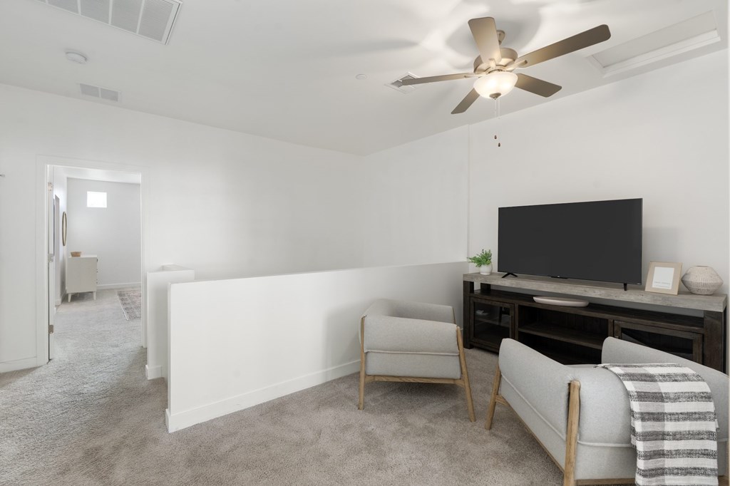 A living room with a television, a chair, and a blanket.