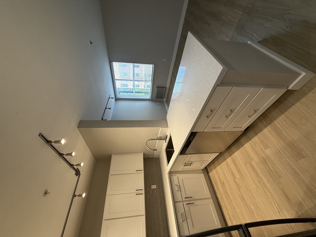 A modern kitchen with a skylight and wooden cabinets.