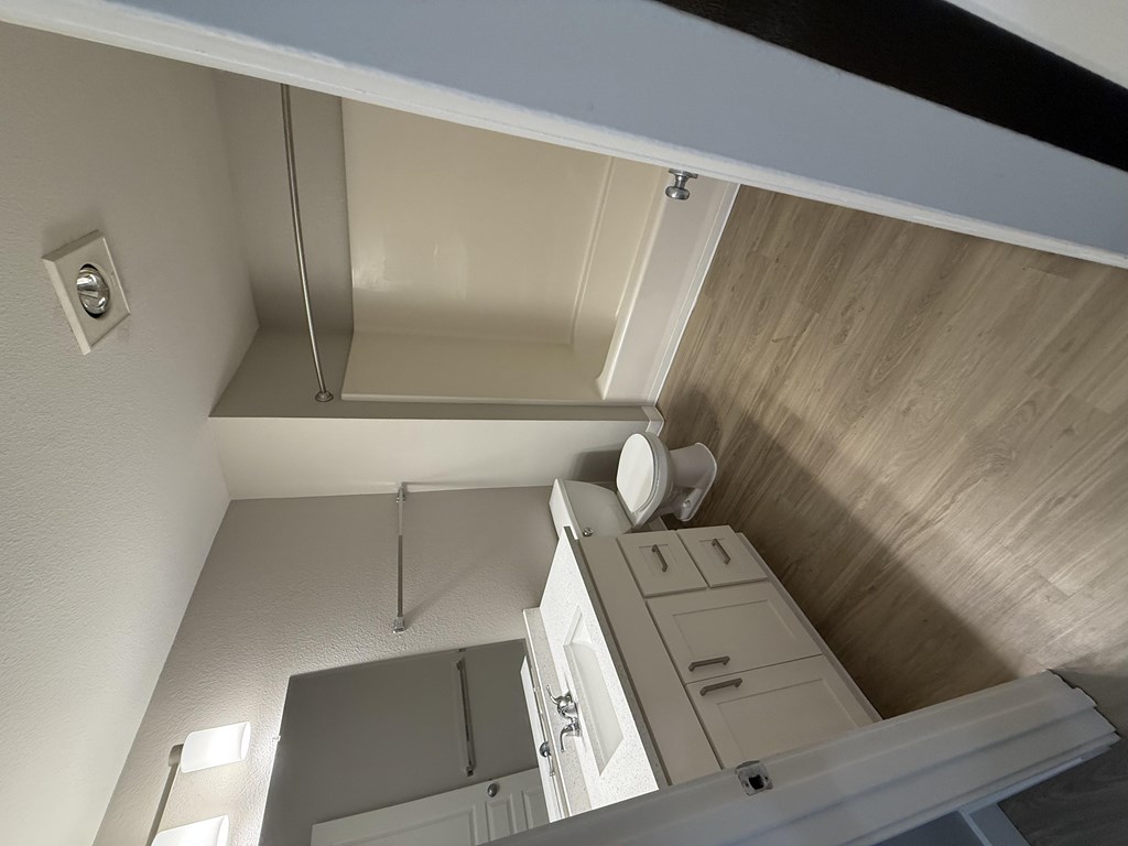 A white cabinet with a white door is in a room with a wooden ceiling.