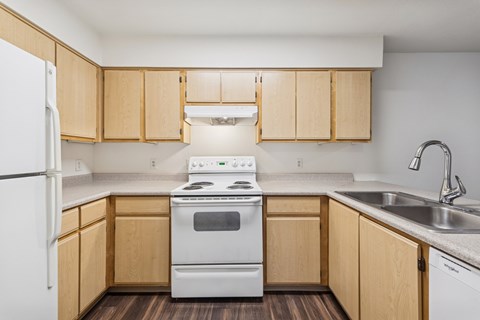 A kitchen with wooden cabinets and a white stove.