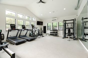 A spacious gym with treadmills, exercise bikes, and weightlifting equipment.