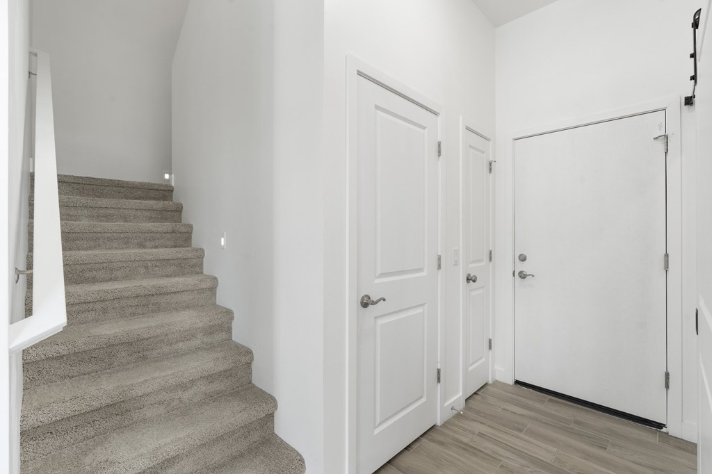 A staircase with a carpeted runner and a white railing.