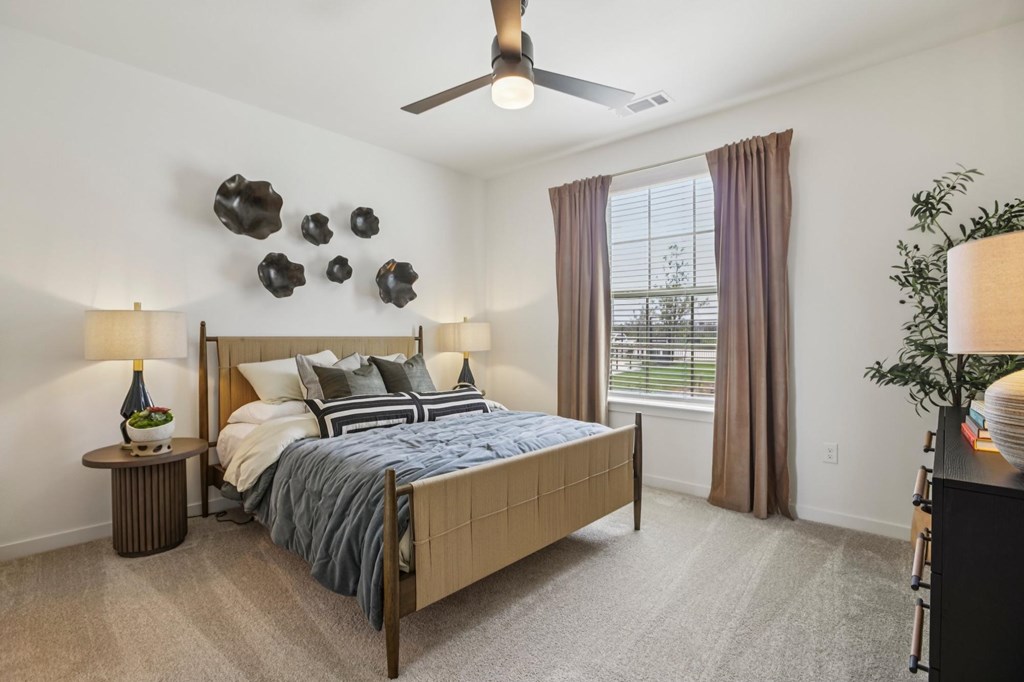 A bedroom with a large bed and a ceiling fan.