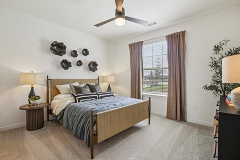 A bedroom with a large bed and a ceiling fan.