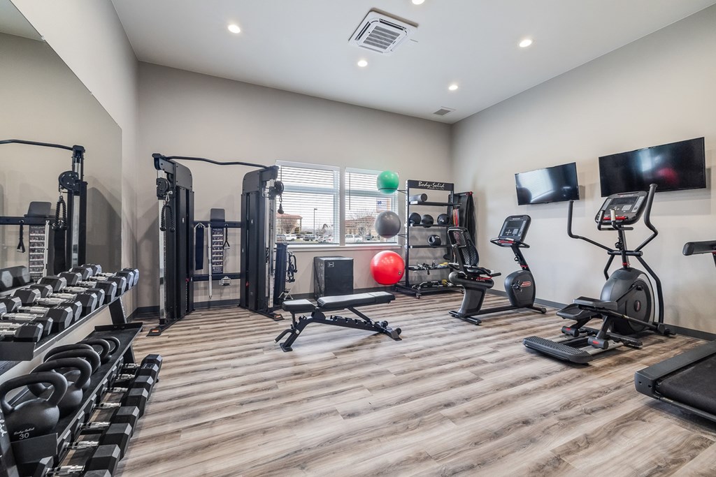 A well-equipped gym with a variety of exercise machines and weights.
