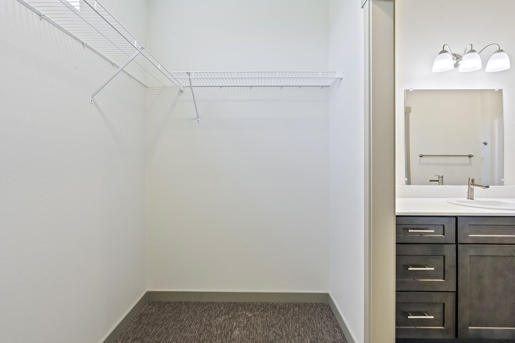 A bathroom with a sink, mirror, and a shelf.