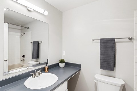 A bathroom with a white sink and a white toilet.