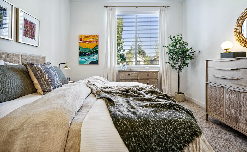 a bedroom with a bed and a dresser and a window