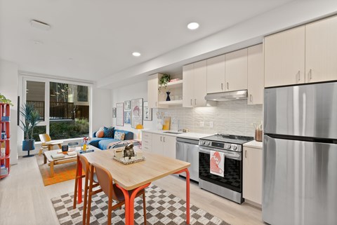 A modern kitchen with a wooden table and stainless steel appliances.