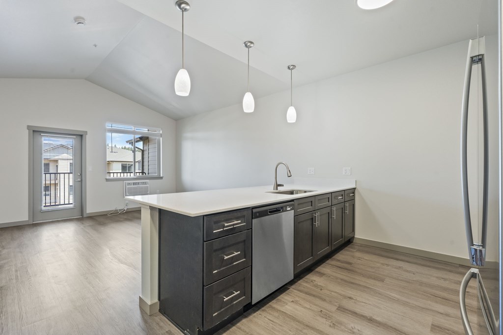 A modern kitchen with a white countertop and black cabinets.