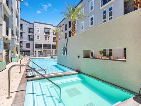 A swimming pool in a residential area with a building in the background.