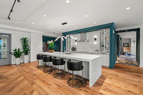a kitchen with a large white island and black stools