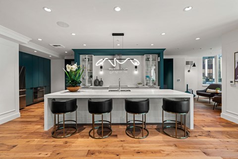 a kitchen with a large island with four black stools