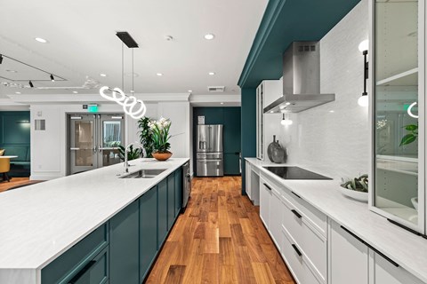 a large kitchen with white counter tops and green cabinets