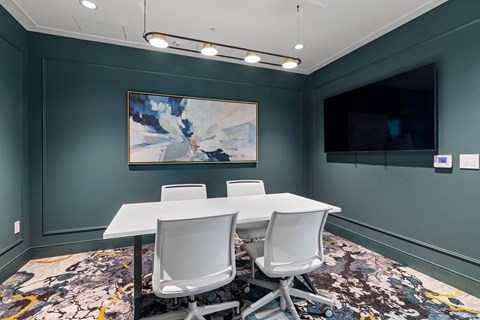 a conference room with a table and chairs and a television