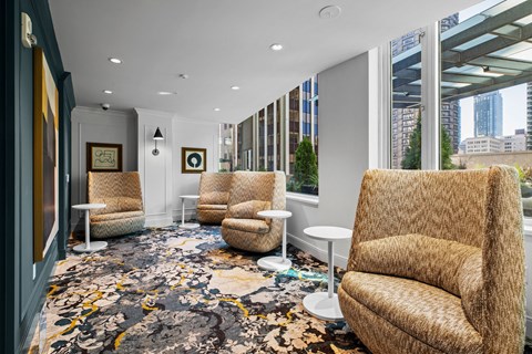 a lobby with chairs and tables and a large window