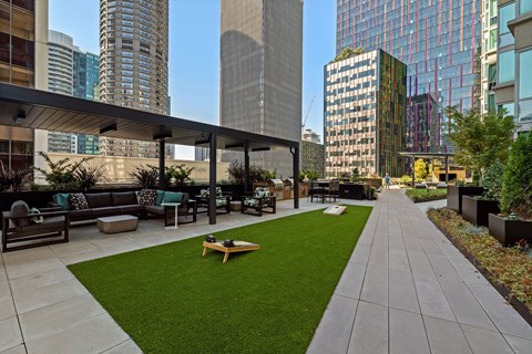 an outdoor lounge area with a lawn and cityscape in the background