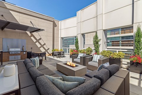 an outdoor patio with couches and chairs and a fire pit