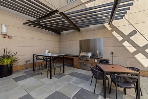 a patio with tables and chairs and a kitchen