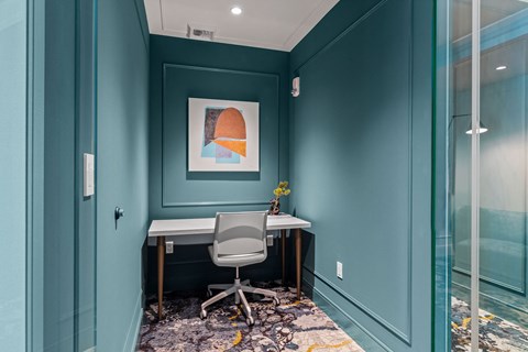 a home office with blue walls and a desk with a chair