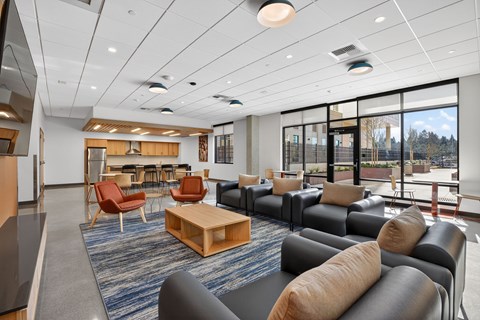 A spacious room with a variety of seating options and a view of the outside.
