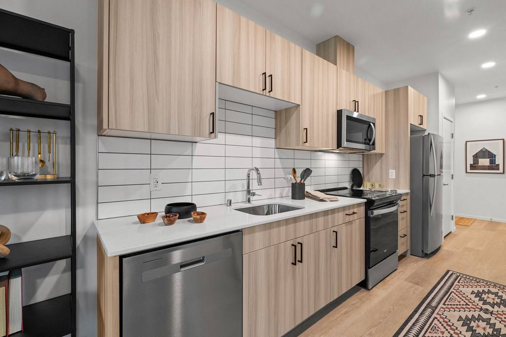 A modern kitchen with wooden cabinets and stainless steel appliances.