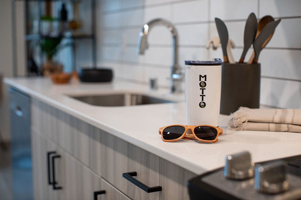 A white container with the word "MOT" on it sits on a kitchen counter.